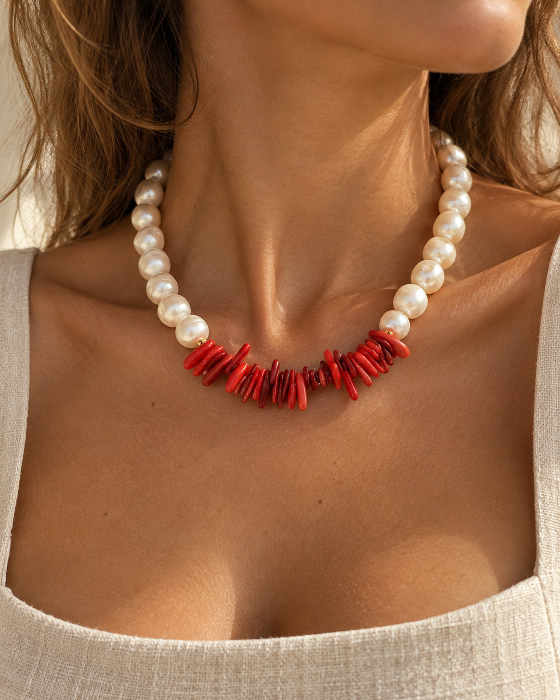 Modelo a usar o colar CORALIA de pérolas e coral vermelho