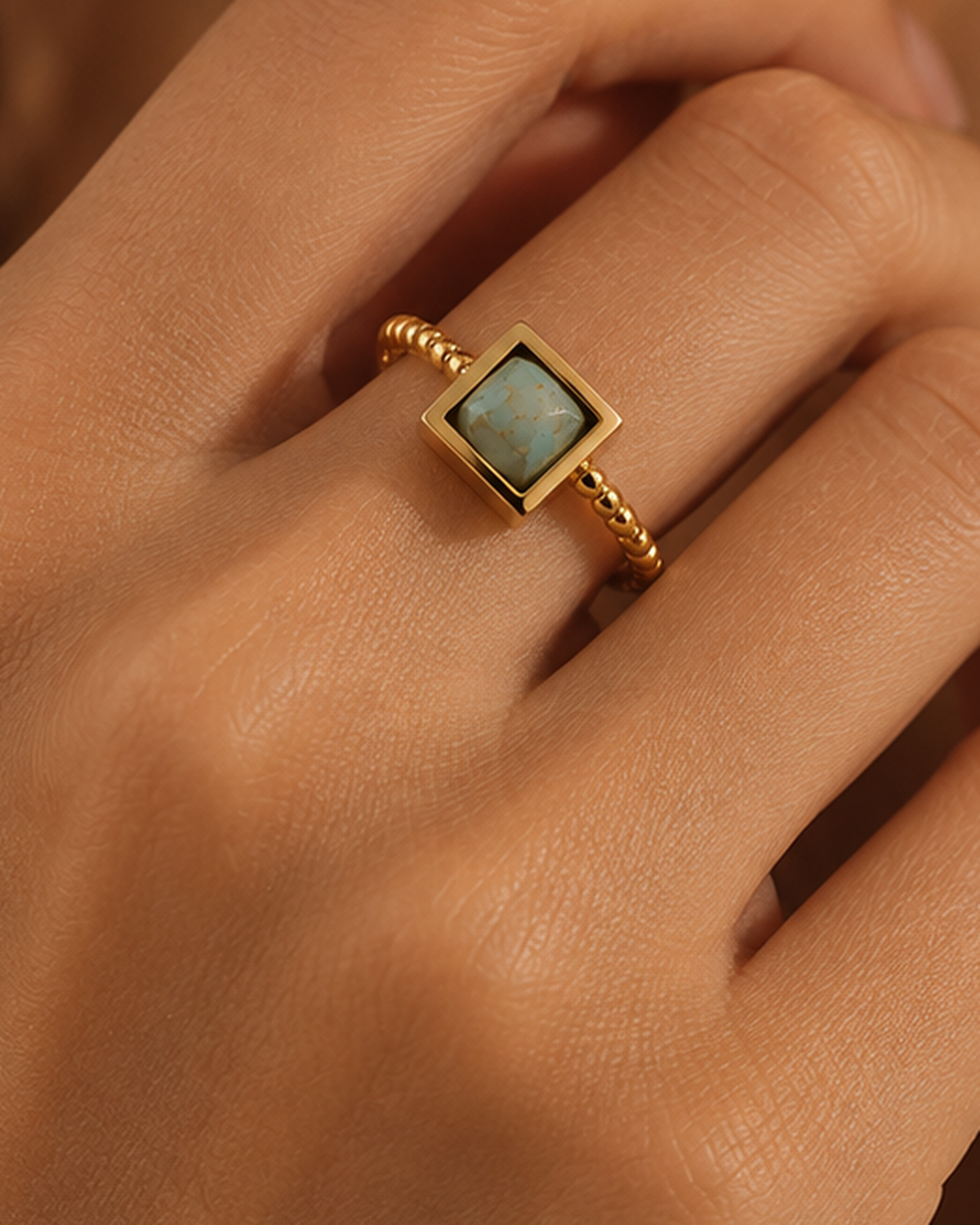 Anel VESTA dourado ajustável colocado no dedo de uma modelo