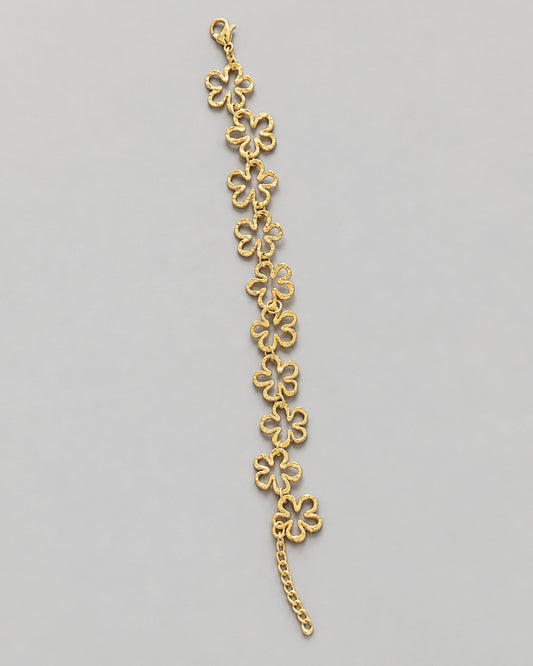 Pulseira LIRIA dourada com dez flores vazadas em aço inoxidável, fecho de mosquetão e corrente extensora
