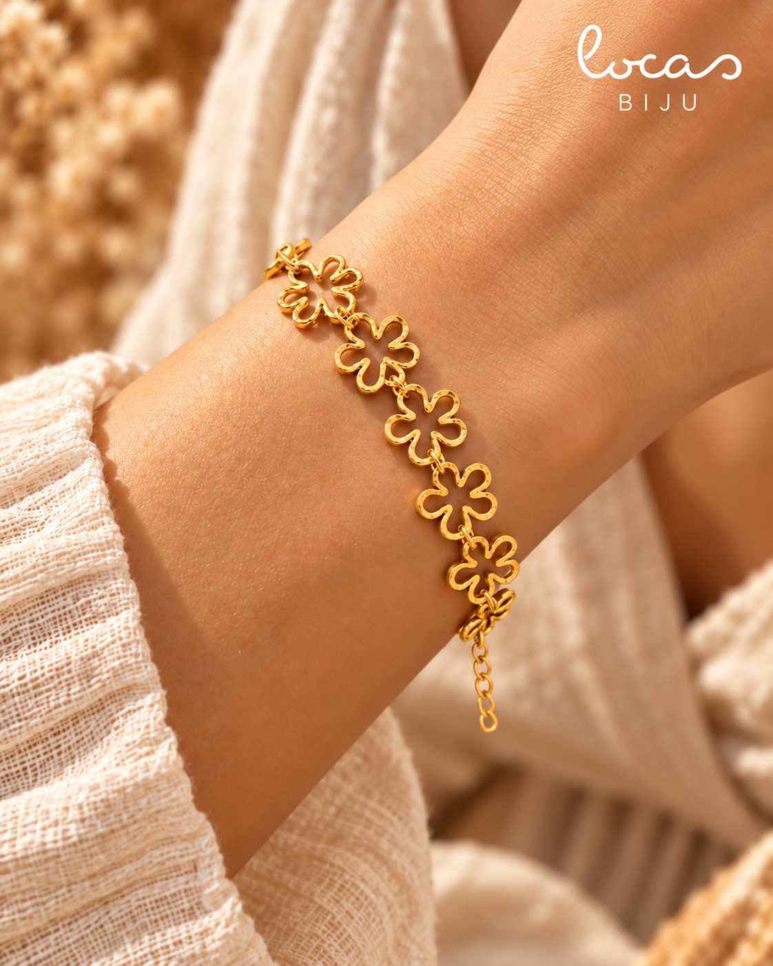 Close-up da pulseira LIRIA dourada com flores no pulso
