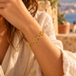 Pulseira LIRIA dourada com flores em contexto lifestyle mediterrânico