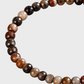 Close-up das contas pequenas facetadas em pedras naturais castanhas, bege, creme e cinza da pulseira masculina ATLAS