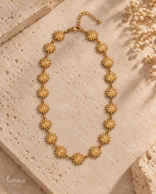 Colar dourado Locas Biju com elementos em forma de sol, fotografia de produto com fecho para cima