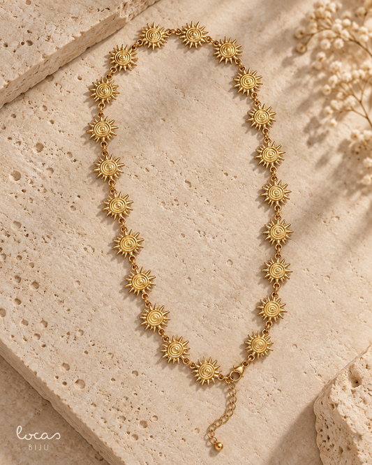 Colar dourado Locas Biju com elementos em forma de sol, fotografia de produto