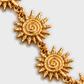 Macro dos sóis em espiral e das argolas do colar SOLEA, fundo cinzento #EBEBEB