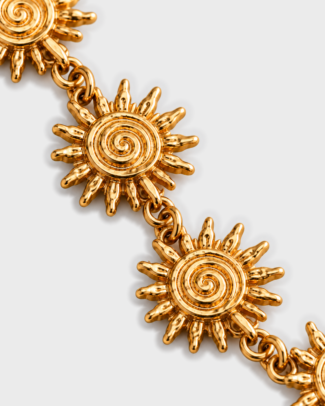 Macro dos sóis em espiral e das argolas do colar SOLEA, fundo cinzento #EBEBEB