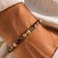 Pulseira masculina TERRA em pedras naturais no pulso de homem com camisa de linho bege