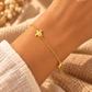 Close-up da pulseira SIREA dourada com tartaruga no pulso