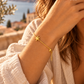 Pulseira SIREA dourada com tartaruga em contexto lifestyle mediterrânico