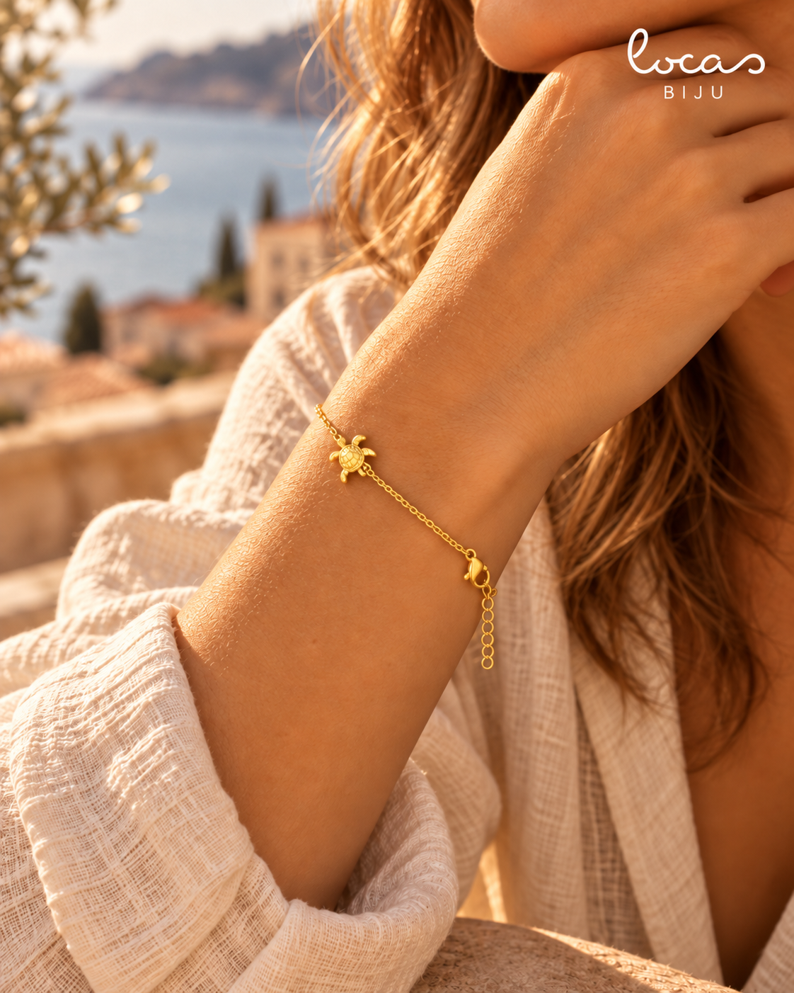 Pulseira SIREA dourada com tartaruga em contexto lifestyle mediterrânico